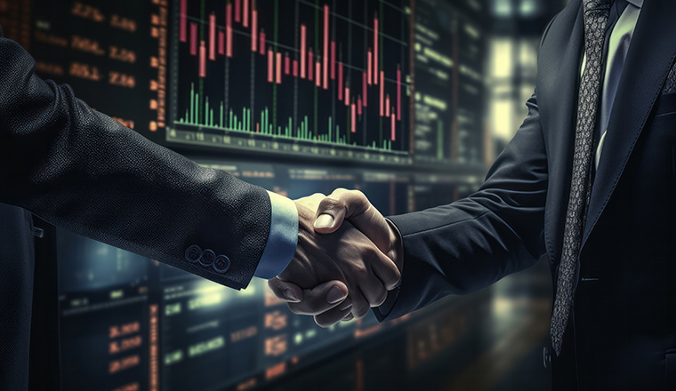 Business handshake by stock market chart. Financial agreement deal or investment concept.