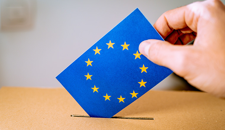 Election in European Union - voting at the ballot box. A hand putting an EU flag vote in the ballot box.