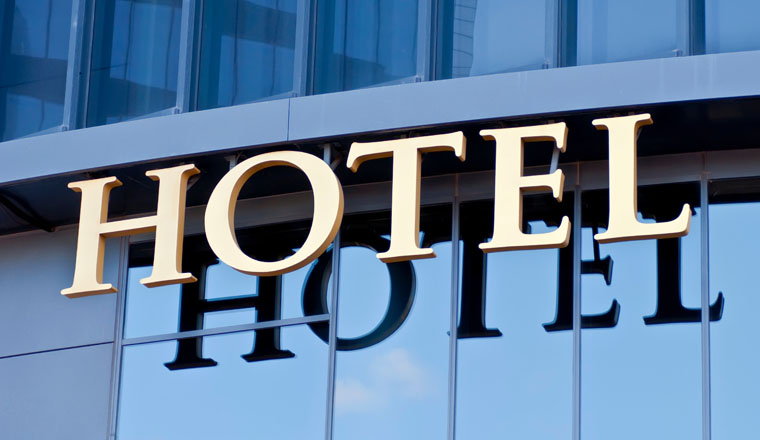 A hotel sign reflected in the glass of the building