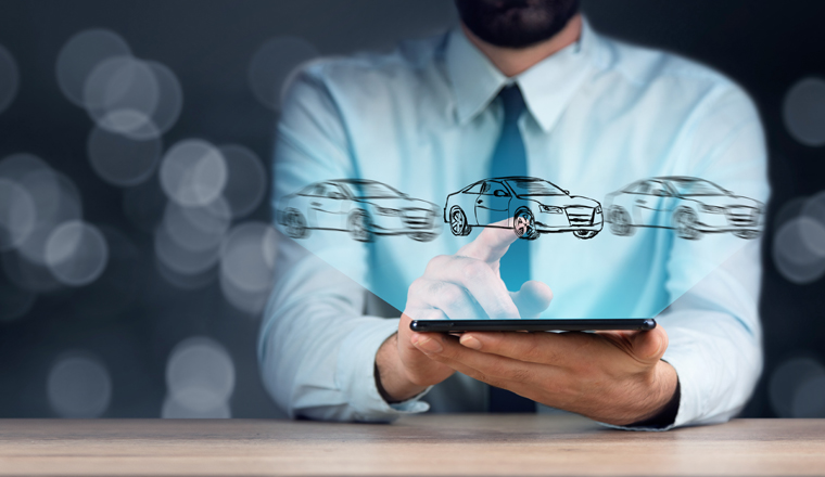 business man holding tablet with car models