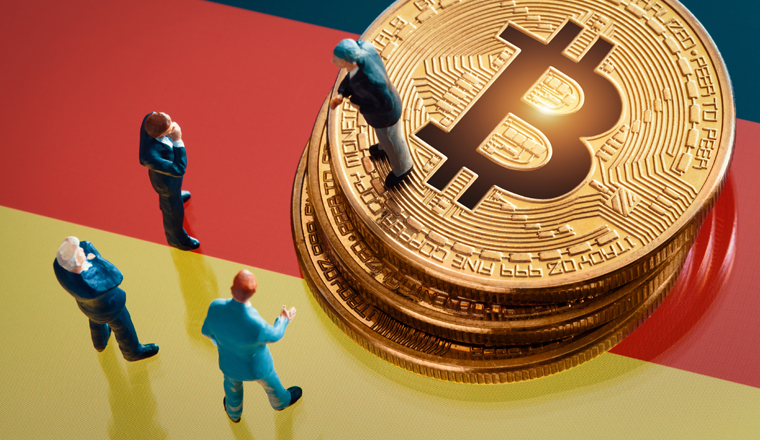 Business meeting about the investment decision for bitcoin concept: Miniature businessman figurines standing near the pile of shiny golden bitcoin on Germany flag.