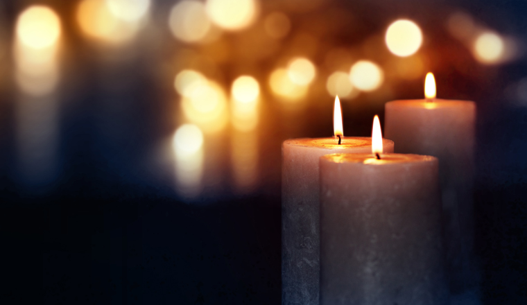 Dark blue background with burning candles and golden bokeh for a solemn occasion