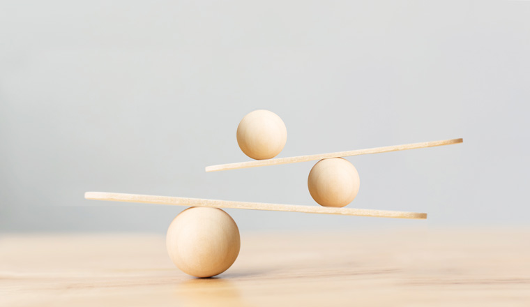 Wooden scale balancing on seesaw. Concept of harmony and balance in life and work