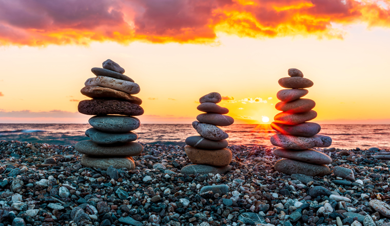 three towewrs or turrets of stone in a nice empty sea beach with coast line guring sunset or sunrise with amazing cloude sky on baclground