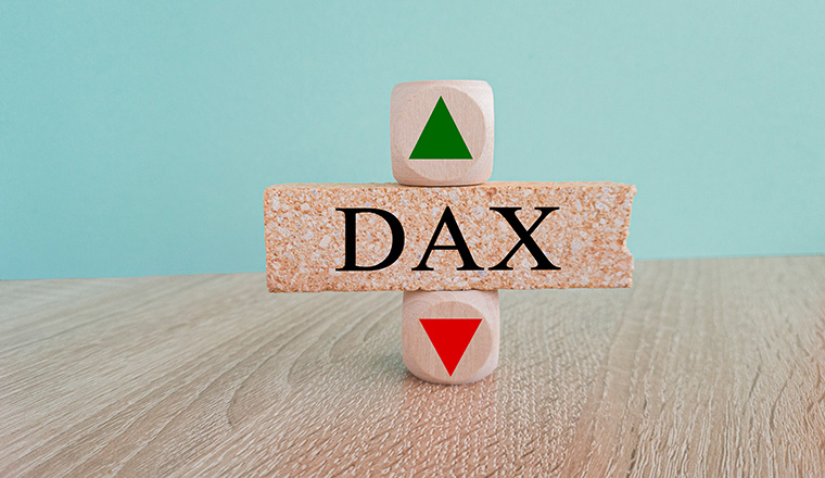 DAX price symbol. A brick block with arrow symbolizing that Deutsche Boerse DAX index price are going down or up. Beautiful blue background. Business and gold price concept. Copy space.
