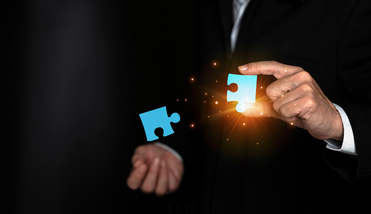 Business solutions, man hands holding jigsaw puzzle icon, target, success, goals and strategy concepts, Mergers and acquisition concept with consultant holding puzzle pieces icons.
