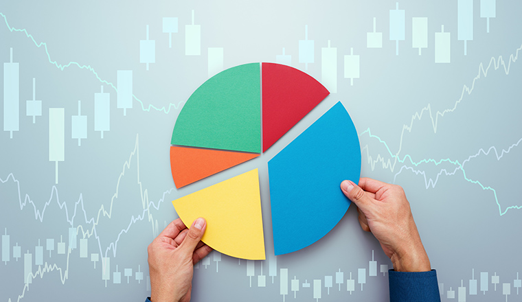 Strategy of diversified investment.  Investor managing portfolio. Pie chart and candlestick charts. 