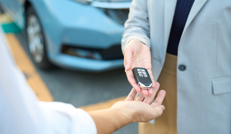 Woman handing over car keys outside