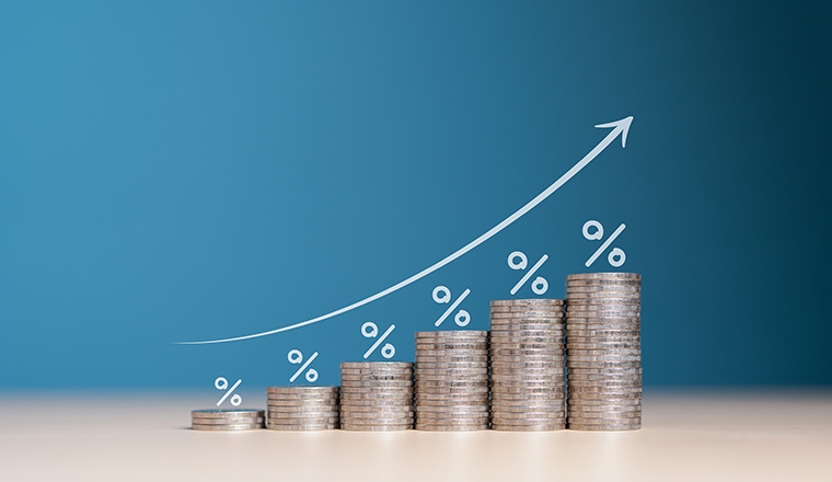 Financial interest rates hike, dividends and mortgage rates increase. Wooden blocks with percentage growth bar and arrow pointing up icon on stacked coins. Inflation, sale price and tax rise concept.