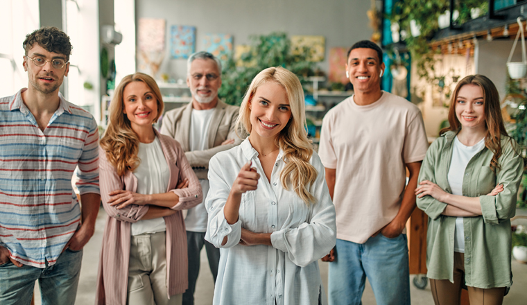 Multiracial creative people in modern office. Group of young business people and senior boss are working together with laptop, tablet, smart phone, notebook, graphs. Successful team in coworking