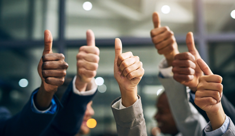 Hands showing thumbs up with business men endorsing, giving approval or saying thank you as a team in the office. Closeup of corporate professionals hand gesturing in the positive or affirmative.