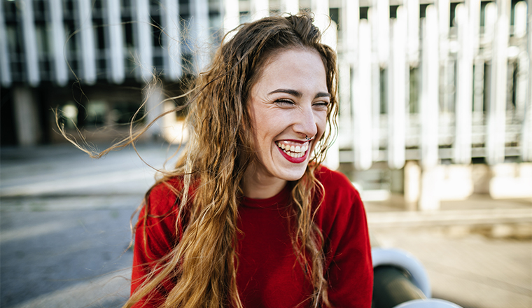 Spain, Madrid, portrait of smiling woman in the street.
