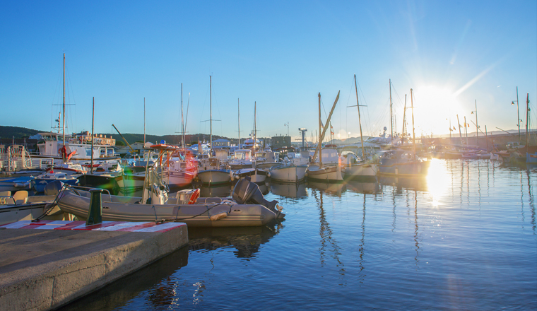 Fishing and pleasure boats in harbour of Saint-Tropez  -  sunset in summer on French Riviera ( D'azure Coast). Pier in right corner