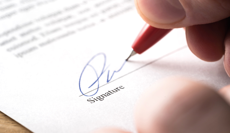 Signing contract, lease or settlement for acquisition, apartment lease, insurance, bank loan, mortgage or business buyout. Man writing name and autograph with pen. The signature is made up. Macro.