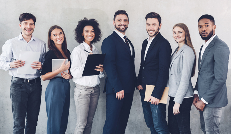 Young business team looking at camera, having break in office, grey background