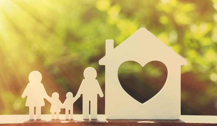 Small model of house and family on blurred background