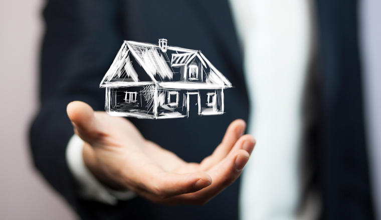 Real estate offer. Businessman holds an artificial model of the house