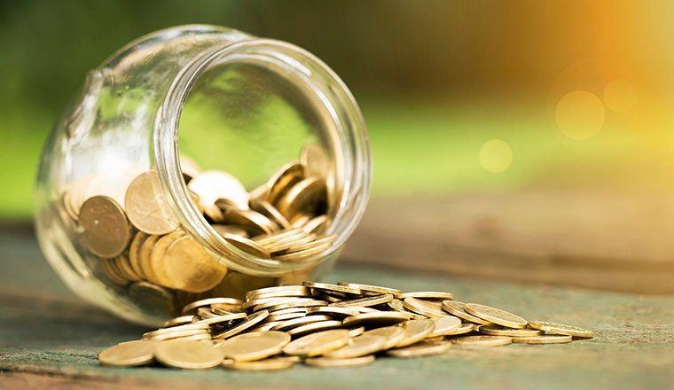 Golden coins in a glass jar - website banner of money savings concept