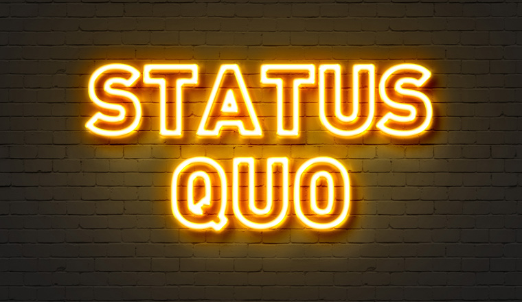 Status quo neon sign on brick wall background