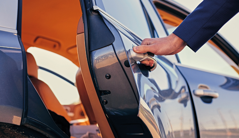 Close up image of a man opens car's door.