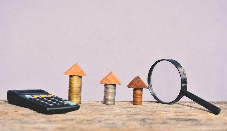 Coin magnifying glass and calculator on wood concept save money for real estate