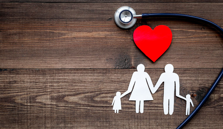 Take out health insurance for family. Stethoscope, paper heart and silhouette of family on wooden background top view.