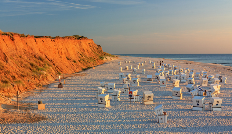 Strand mit Strandkörben am Roten Kliff bei Kampen auf Sylt an der Nordsee bei Sonnenuntergang.Beach with strandkorbs (beach basket chairs) at the Red Cliff(Rotes Kliff) at sunset near Kampen on Sylt at the North Sea, Schleswig-Holstein, Germany.