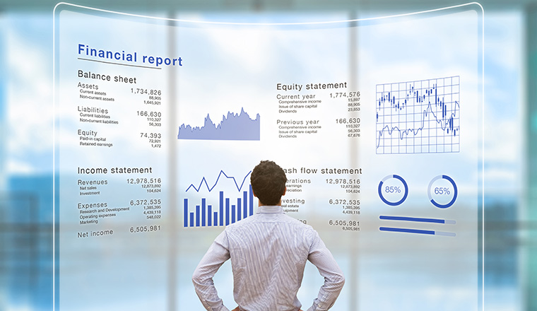 Businessman analyzing financial report data of the company operations (balance sheet, income statement) on virtual computer screen with business charts, fintech