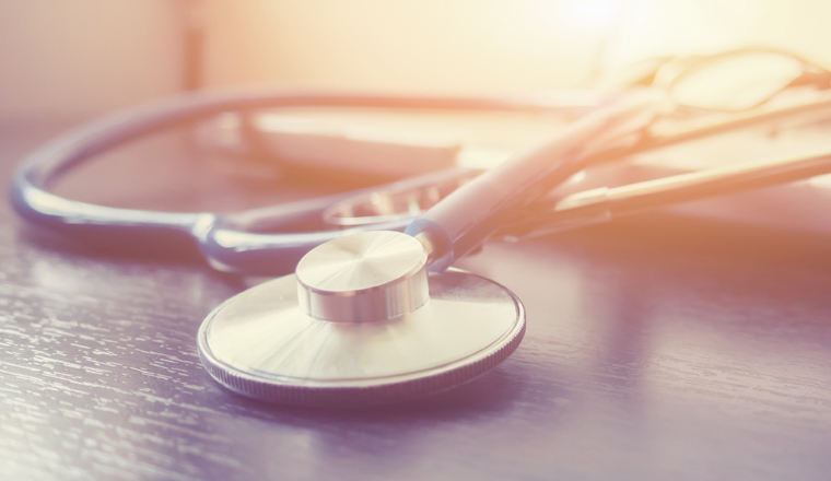 Stethoscope and laptop keyboard on desktop in hospital,relax time doctor,medical concept,selective focus,vintage color.morning light