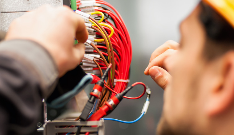 Electrician engineer tests electrical installations and wires on relay protection system. Bay control unit. Medium voltage switchgear