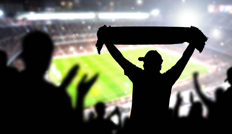 Crowd and fans in football stadium. People in soccer game. Person celebrating goal and holding merchandise scarf for favourite club and team in match. Happy live sport silhouette audience cheering.