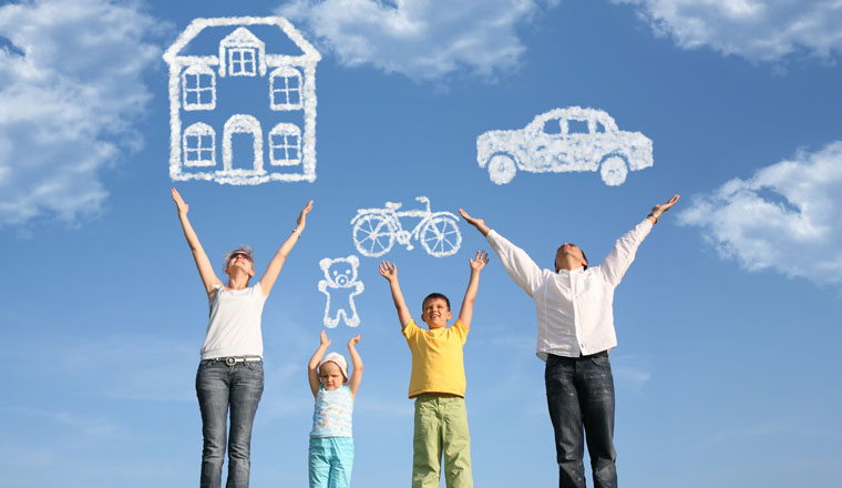 family of four on grass with hands up and dream