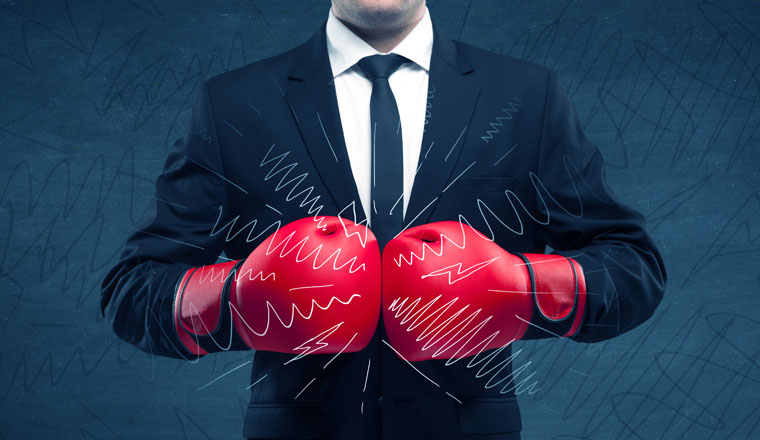 A confident businessman standing in red boxing gloves on his hand in front of blue wall background with drawn strength lines illustration concept.