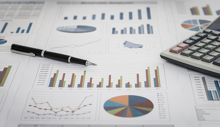 financial graph and chart report with pen, calculator on desk of financial advisor.