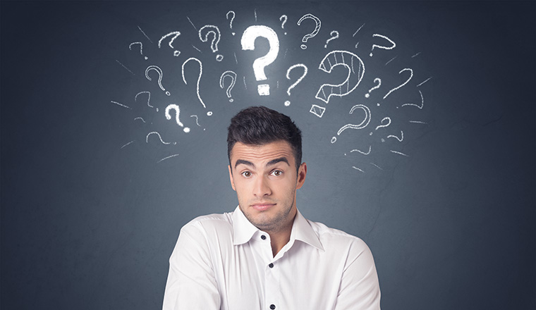 Young casual businessman with white question marks above his head