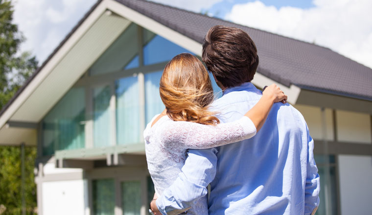 Happy couple walking looking at their house