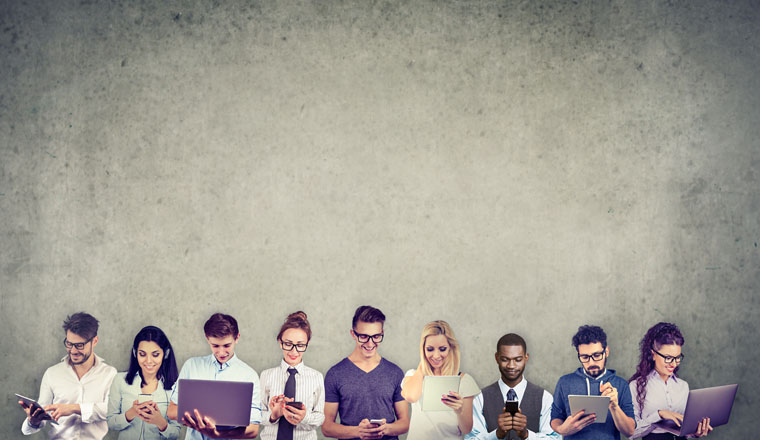 Group of multicultural people men and women connected to each other by using digital mobile gadgets and computers