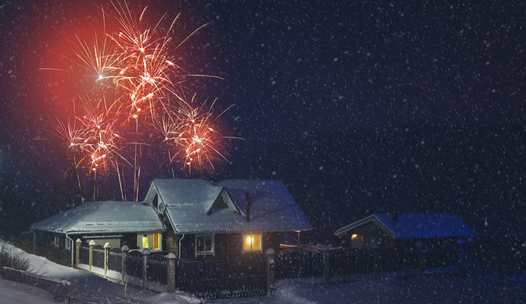 Christmas countryside night background during snow with firework. Group of two night country house with yellow lights, snowing, firework.