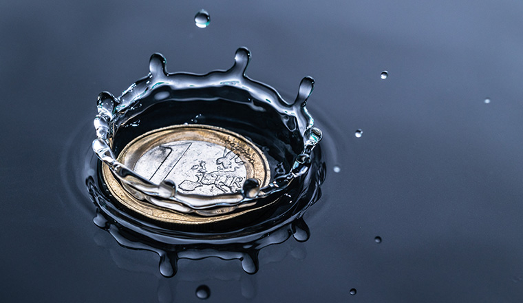 impact of a water drop splash on a euro coin in red water