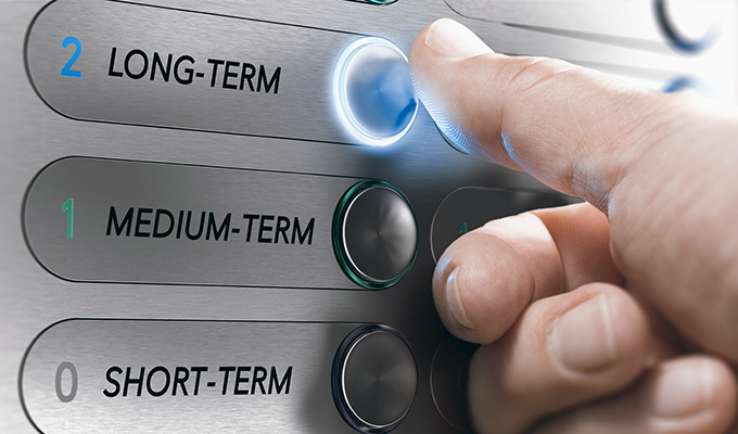 Man pushing an elevator buttons where it is written long term. Investment Concept. Composite image between a hand photography and a 3D background.