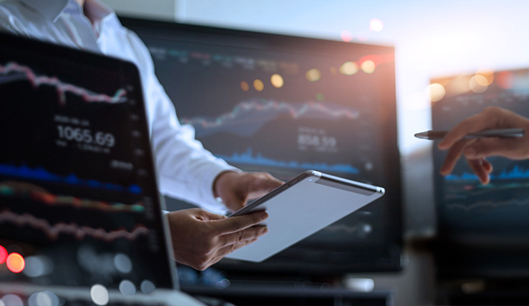 Business team working together. Businessman using tablet for analyzing data stock market in monitoring room with team pointing on the data presented in the chart on screen, forex trading graph, stock exchange trading online, financial investment concept. All on laptop screen are design up.