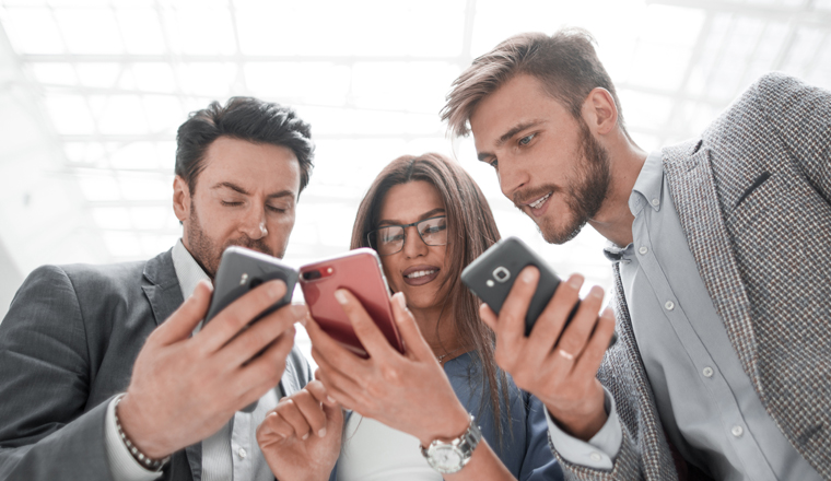 close up.business colleagues reading SMS on their smartphones. people and technology