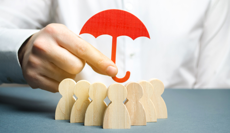 Boss holding a red umbrella and defending his team with a gesture of protection. Life insurance. Customer care, care for employees. Security and safety in a business team. Selective focus