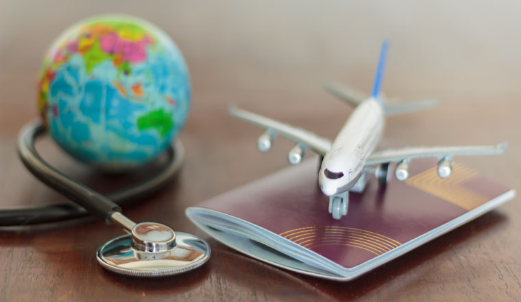 Stethoscope , passport document, airplane and globe. Healthcare and travel insurance concept