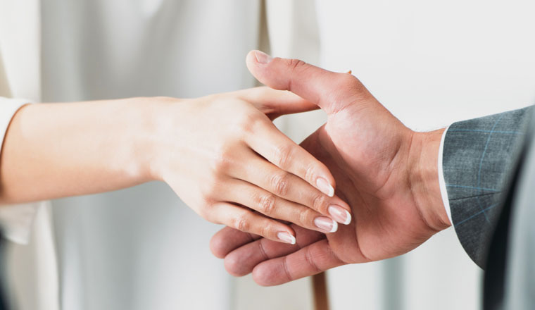 selective focus of man and woman shaking hands at office 