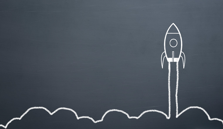 chalk drawing rocket on blackboard Going up quickly