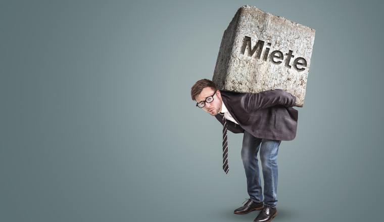 Businessman carrying a large and heavy stone on his back