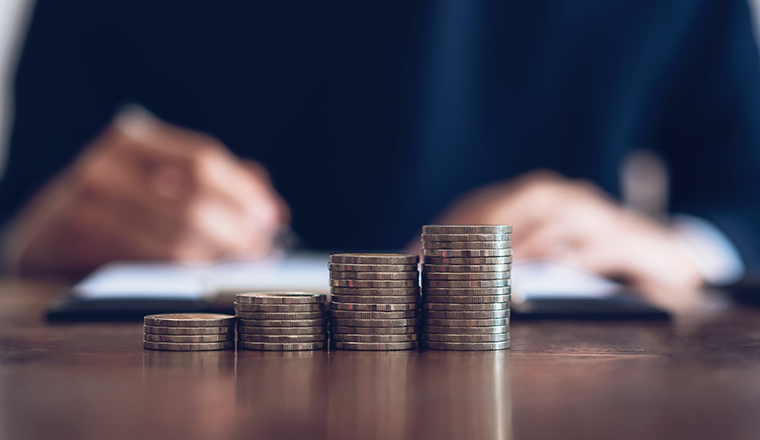 Coin to stack money, financial Business Growth. Men background is signing documents.