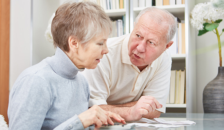 Senioren Paar beim rechnen mit Taschenrechner und Kassenzetteln 