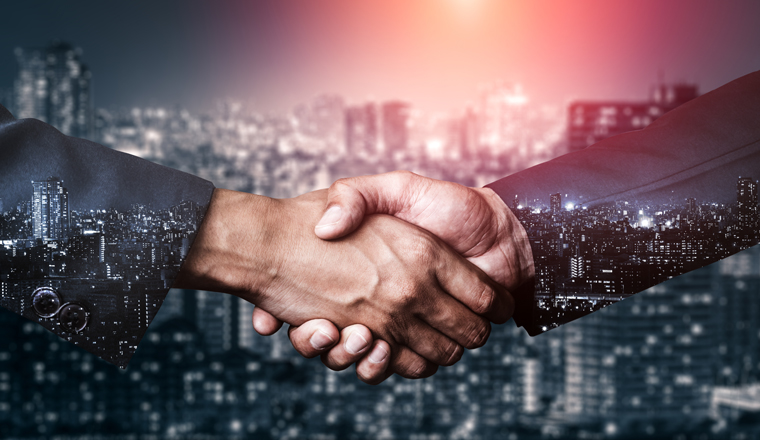 Double exposure image of business people handshake on city office building in background showing partnership success of business deal. Concept of corporate teamwork, trust partner and work agreement.